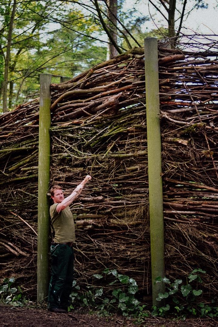 Ein Mann vor einem selbstgebautem Zaun.