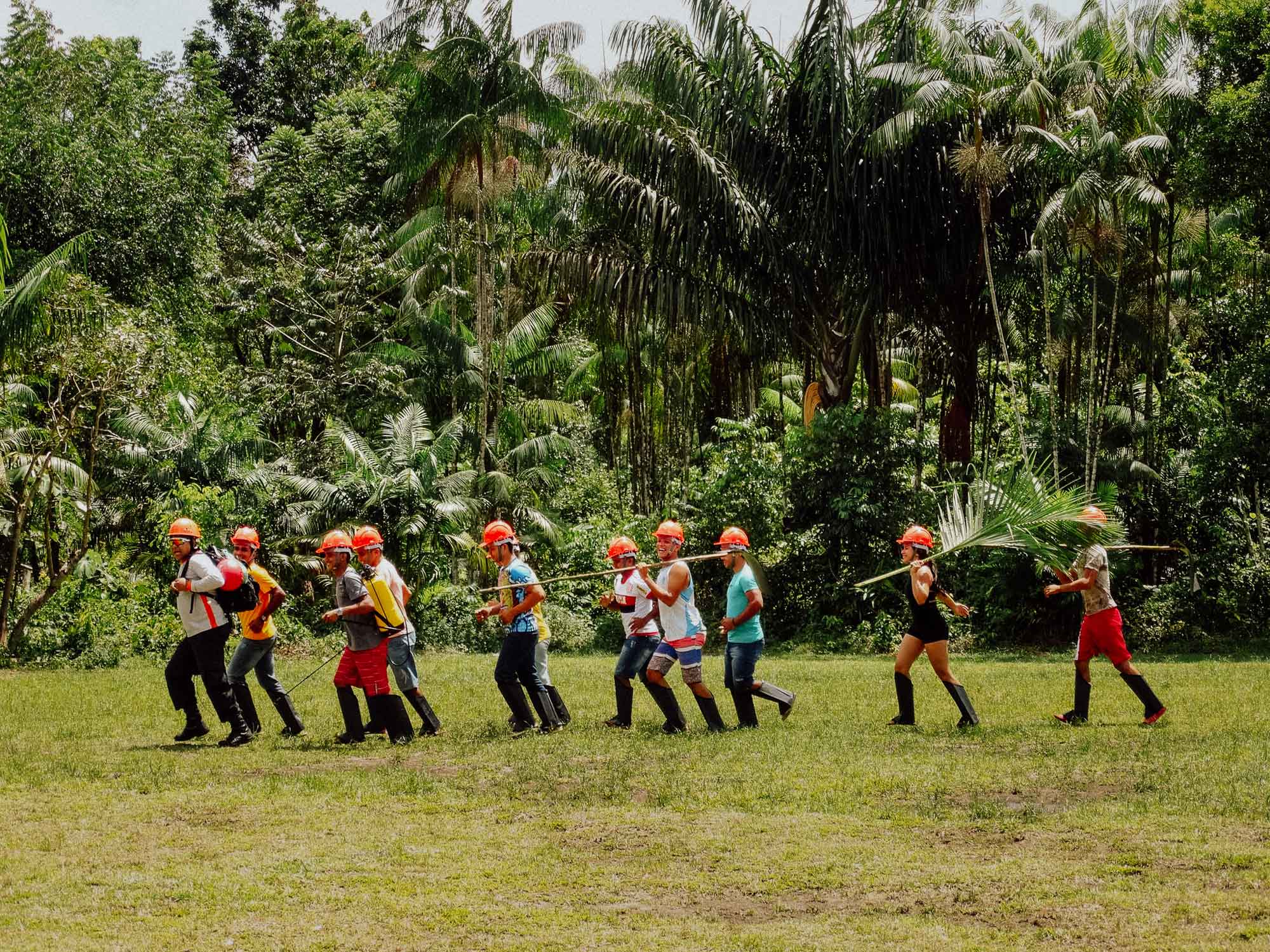 Männer und Frauen bei der Arbeit mit orangenen Helmen.